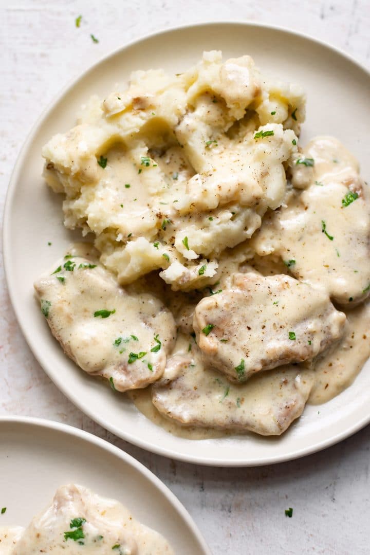 creamy pork tenderloin medallions close-up on a plate with mashed potatoes