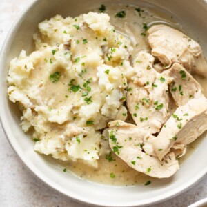 close-up of slow cooker chicken and gravy over mashed potatoes