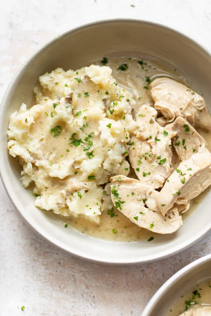 close-up of slow cooker chicken and gravy over mashed potatoes