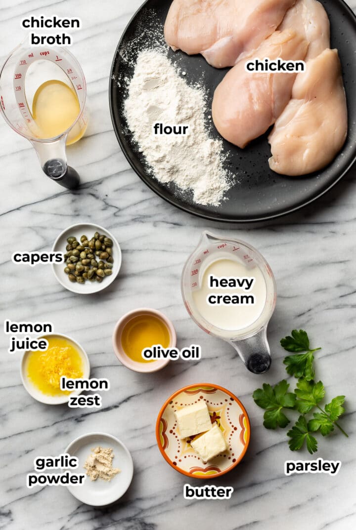 ingredients in small bowls on a marble surface for chicken piccata