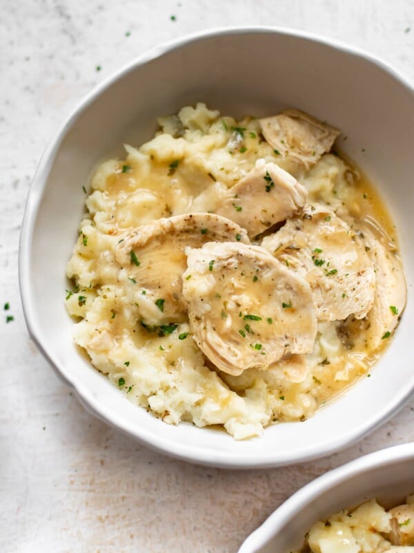 Instant Pot chicken and gravy with mashed potatoes in two white bowls