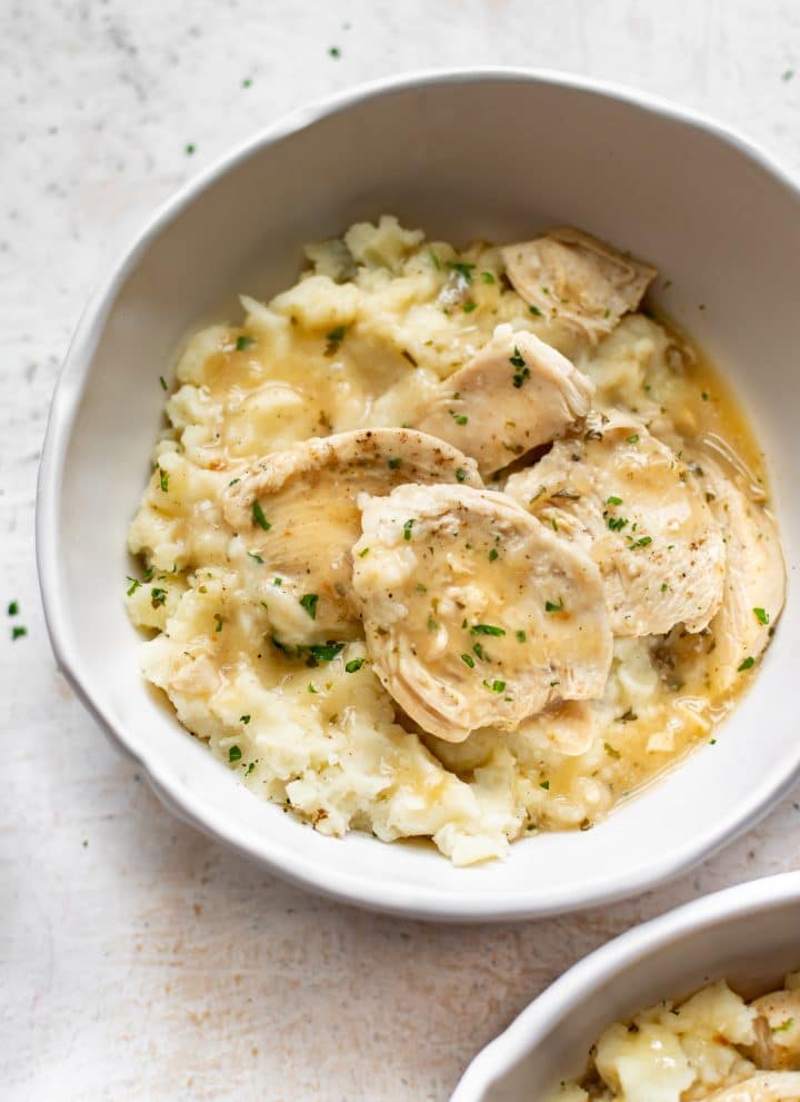 Instant Pot chicken and gravy with mashed potatoes in two white bowls