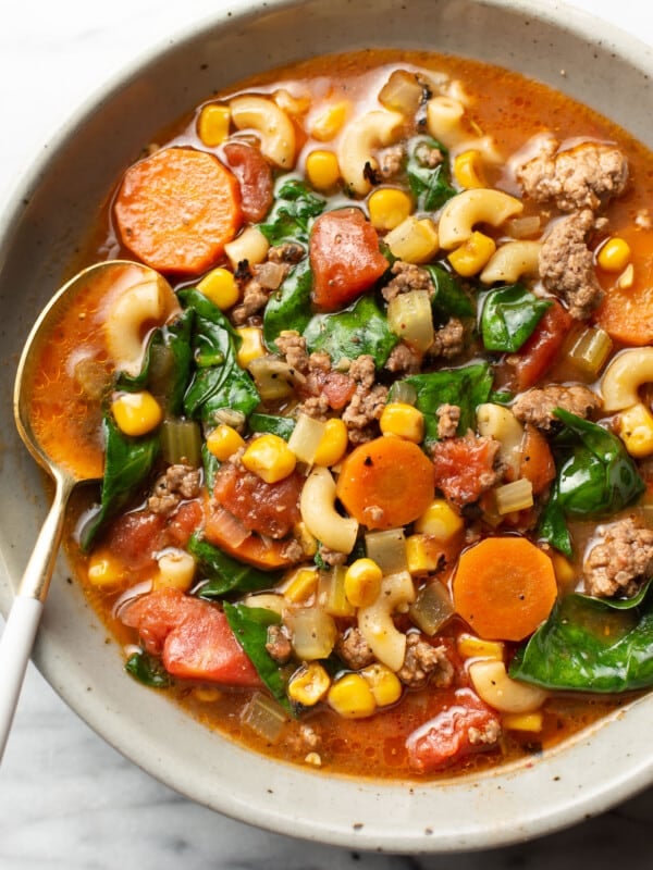 a bowl of ground beef macaroni soup with a spoon