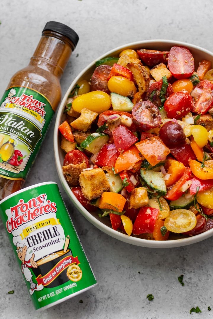 Cajun panzanella salad in a bowl with Tony Chachere's Original Creole Seasoning and Italian Salad Dressing