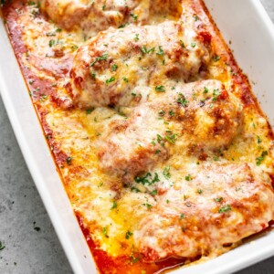 cheesy mozzarella chicken bake with marinara sauce in a baking dish