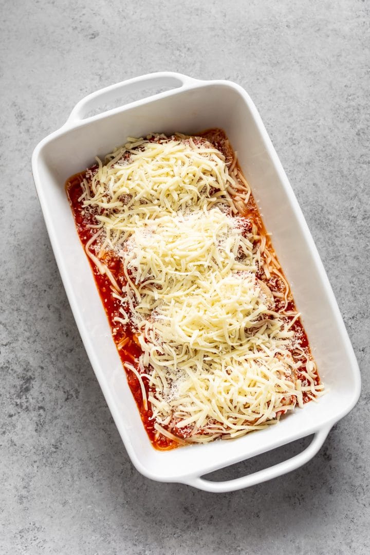 chicken breasts topped with parmesan and mozzarella - ready for the oven!