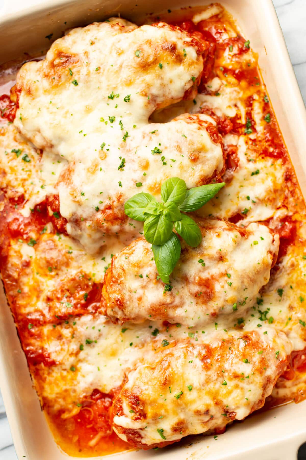 a casserole dish with cheesy mozzarella chicken