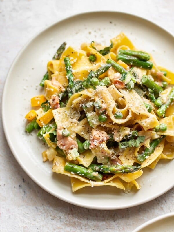 close-up of creamy pasta primavera on a beige plate