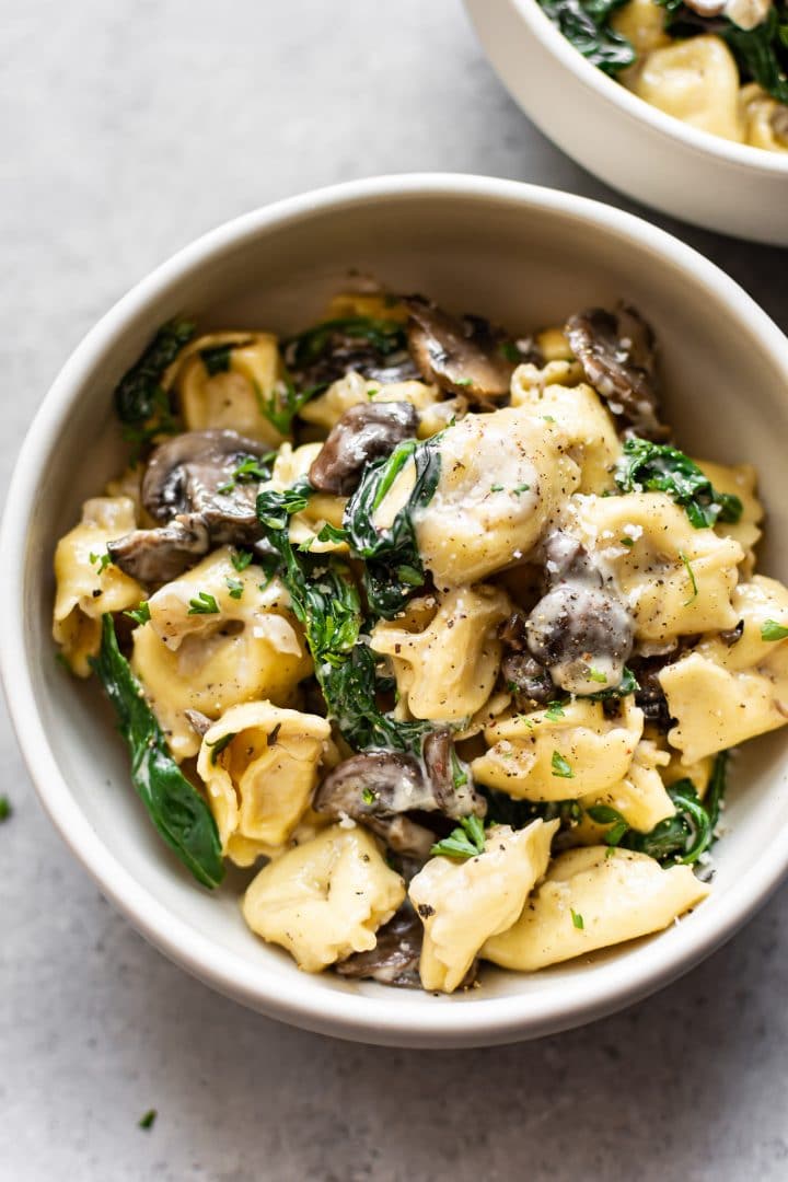 creamy spinach mushroom tortellini in two bowls