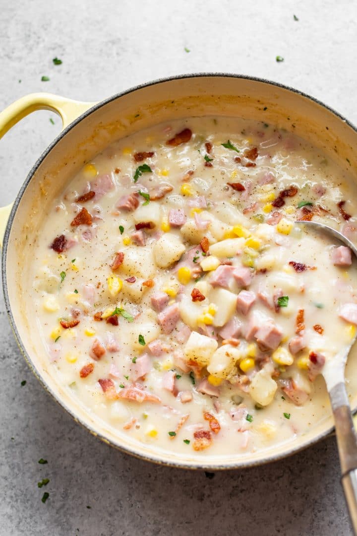 Ham and potato corn chowder in a yellow soup pot