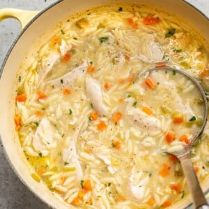 close-up of lemon chicken orzo soup in a yellow pot