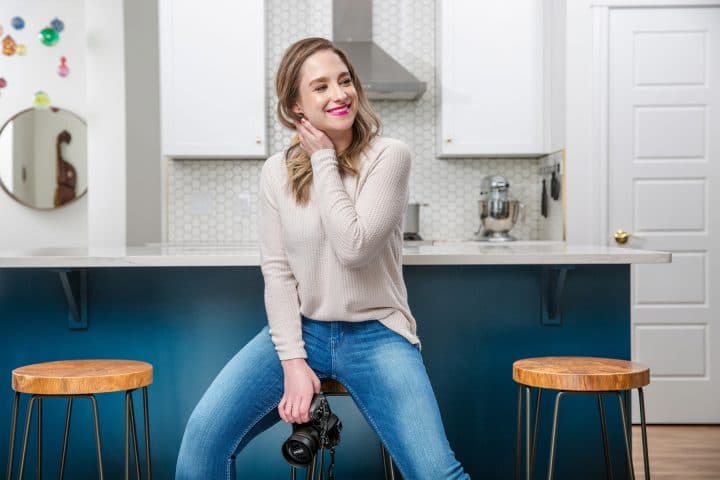 Natasha Bull (author, photographer, and blogger behind the food blog Salt & Lavender) holding her camera in the kitchen