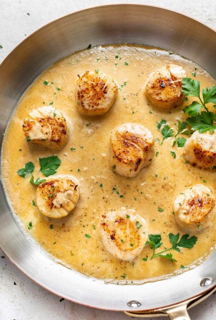 pan-seared scallops with creamy lemon garlic butter sauce in a skillet