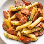 close-up of balsamic smoked sausage pasta in a white bowl