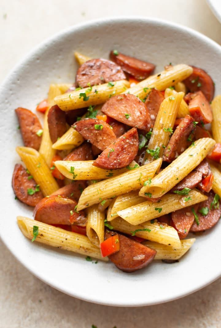 close-up of balsamic smoked sausage pasta in a white bowl