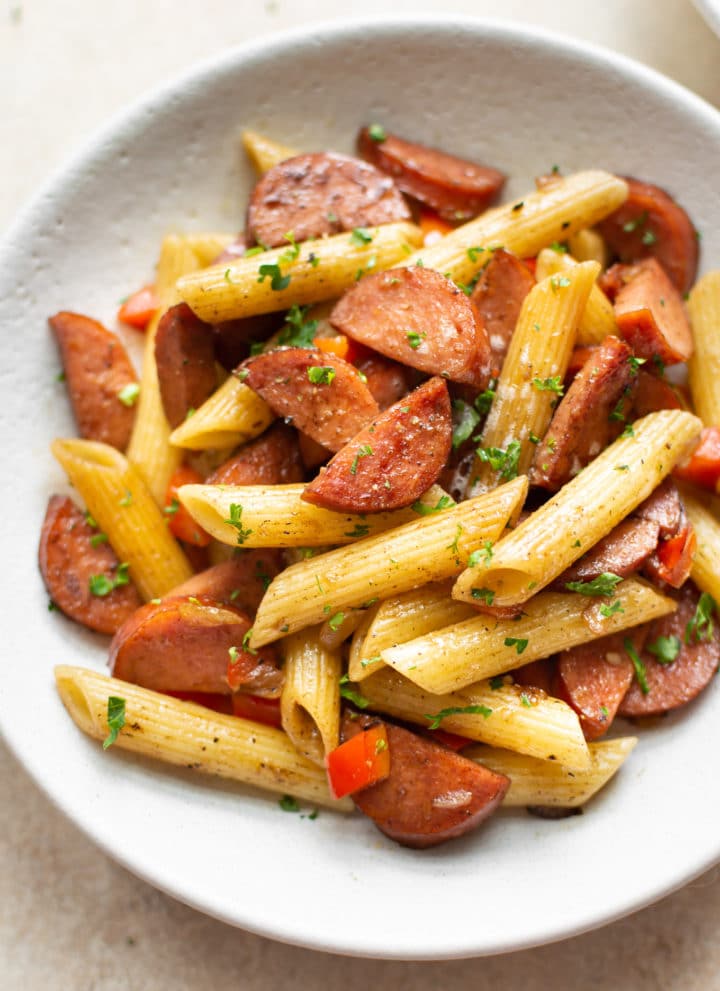 close-up of balsamic smoked sausage pasta in a white bowl