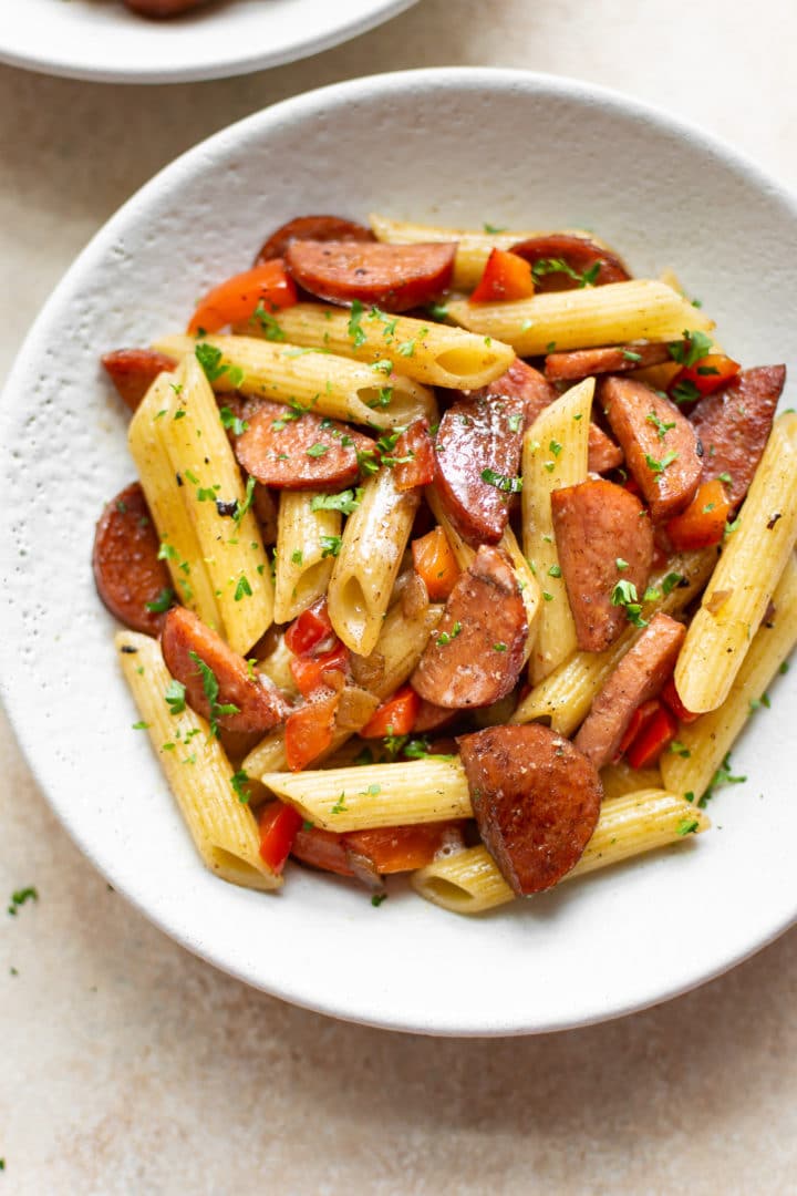 smoked sausage pasta (with penne) in a white bowl