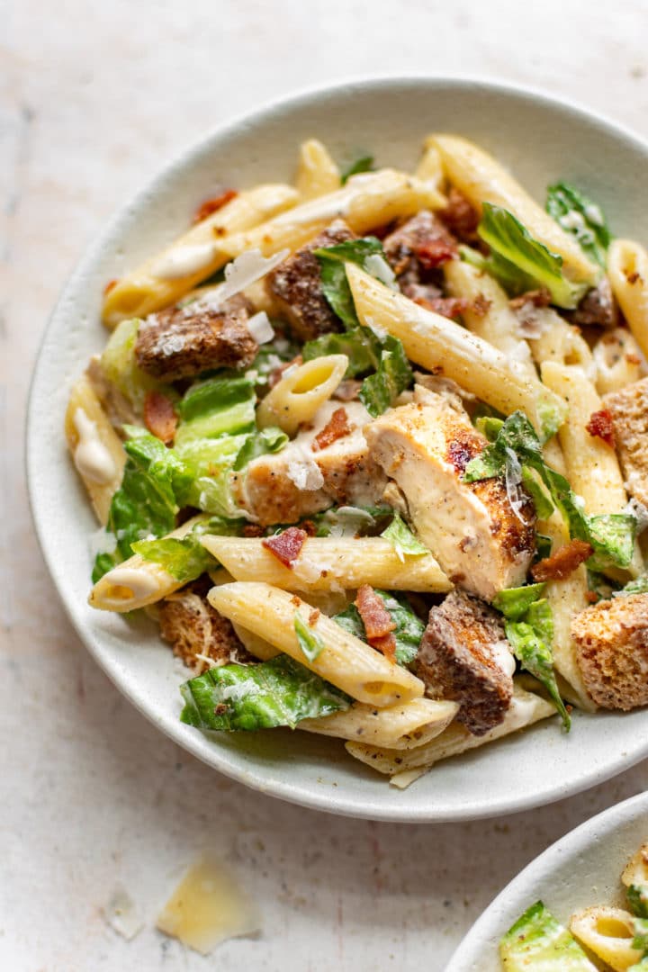 chicken caesar pasta salad plated in two bowls