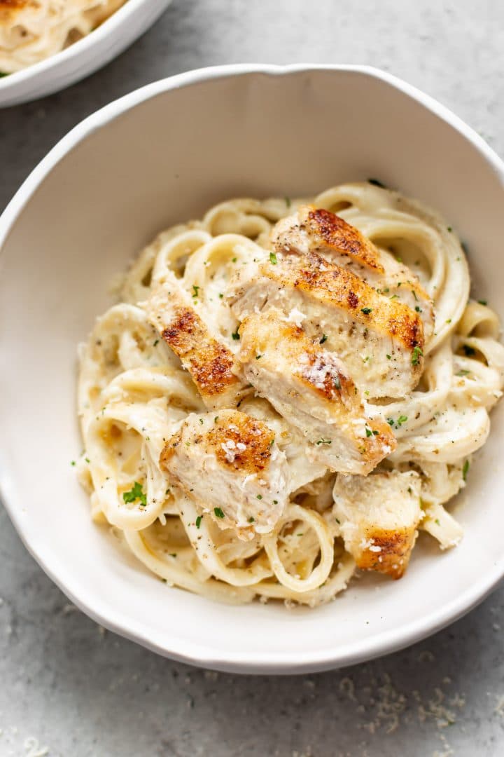 the BEST chicken fettuccine alfredo recipe... plated in two white bowls
