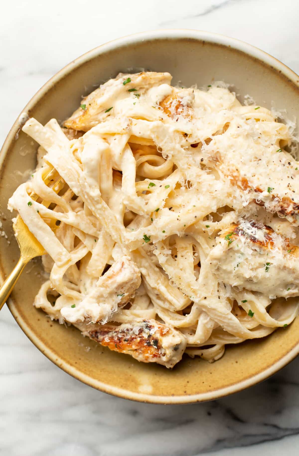 a bowl of chicken fettuccine alfredo with a fork