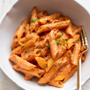 tomato and goat cheese penne close-up with a gold fork