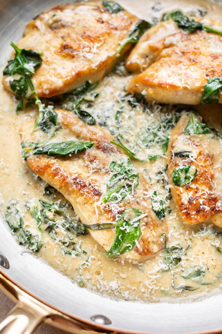 chicken florentine (chicken in spinach garlic cream sauce) close-up in skillet