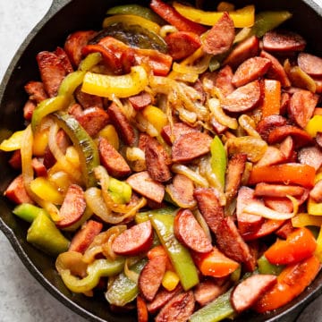 sausage peppers and onions in a cast iron skillet