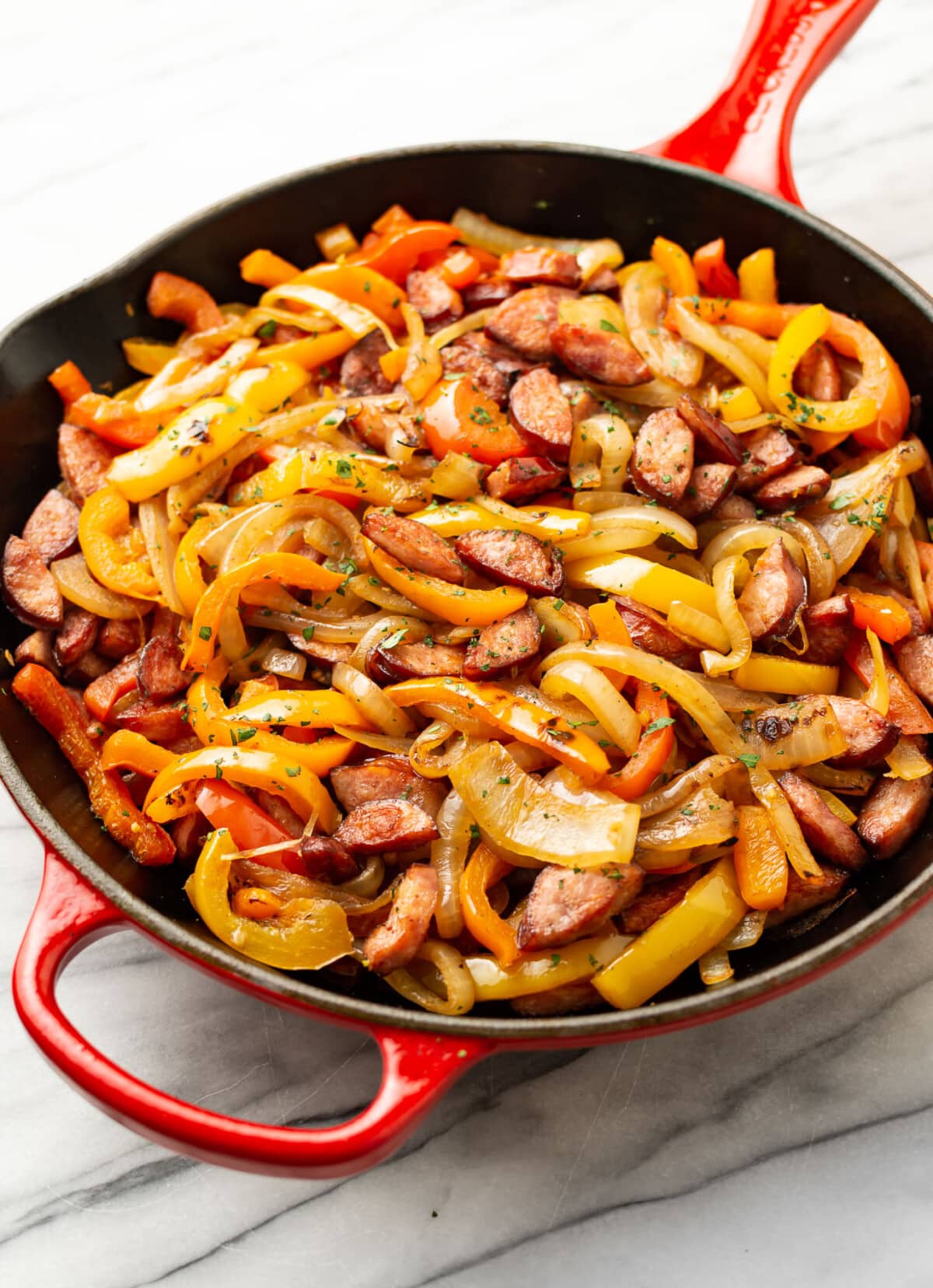 a cast iron skillet with sausage and peppers