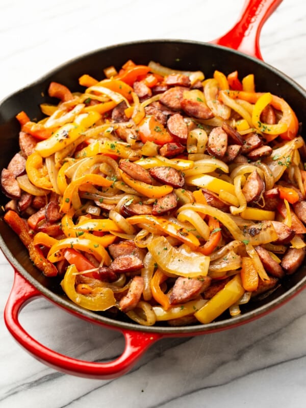 a cast iron skillet with sausage and peppers