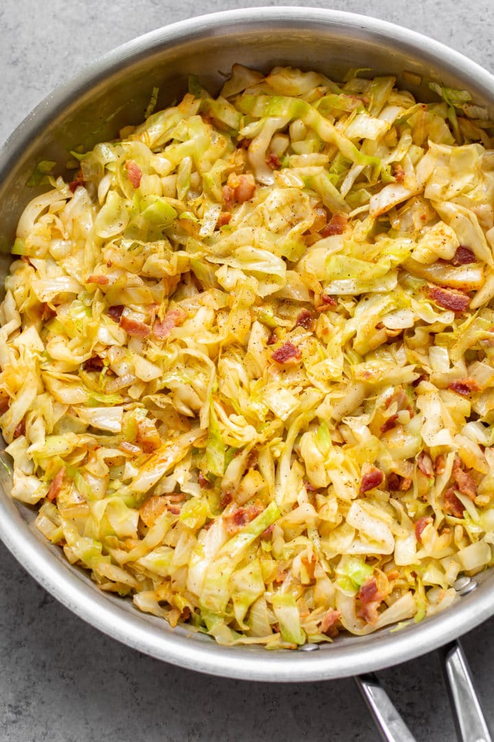 cabbage and bacon in a stainless steel skillet