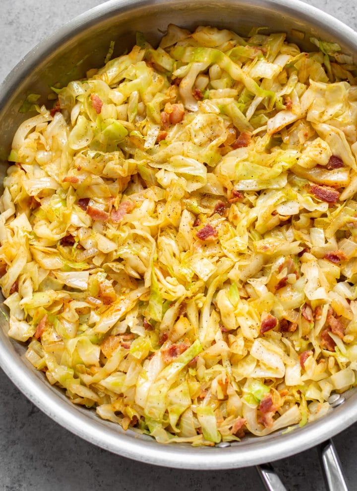 cabbage and bacon in a stainless steel skillet