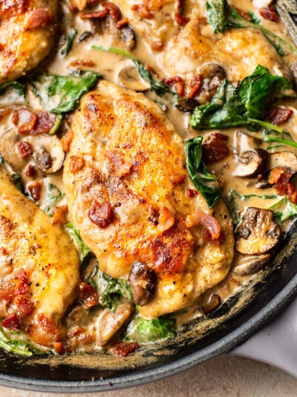 close-up of creamy balsamic bacon mushroom spinach chicken in a skillet