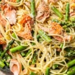 close-up in a copper skillet of creamy salmon and asparagus pasta