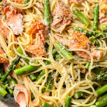 close-up in a copper skillet of creamy salmon and asparagus pasta