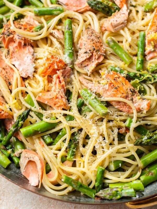 close-up in a copper skillet of creamy salmon and asparagus pasta