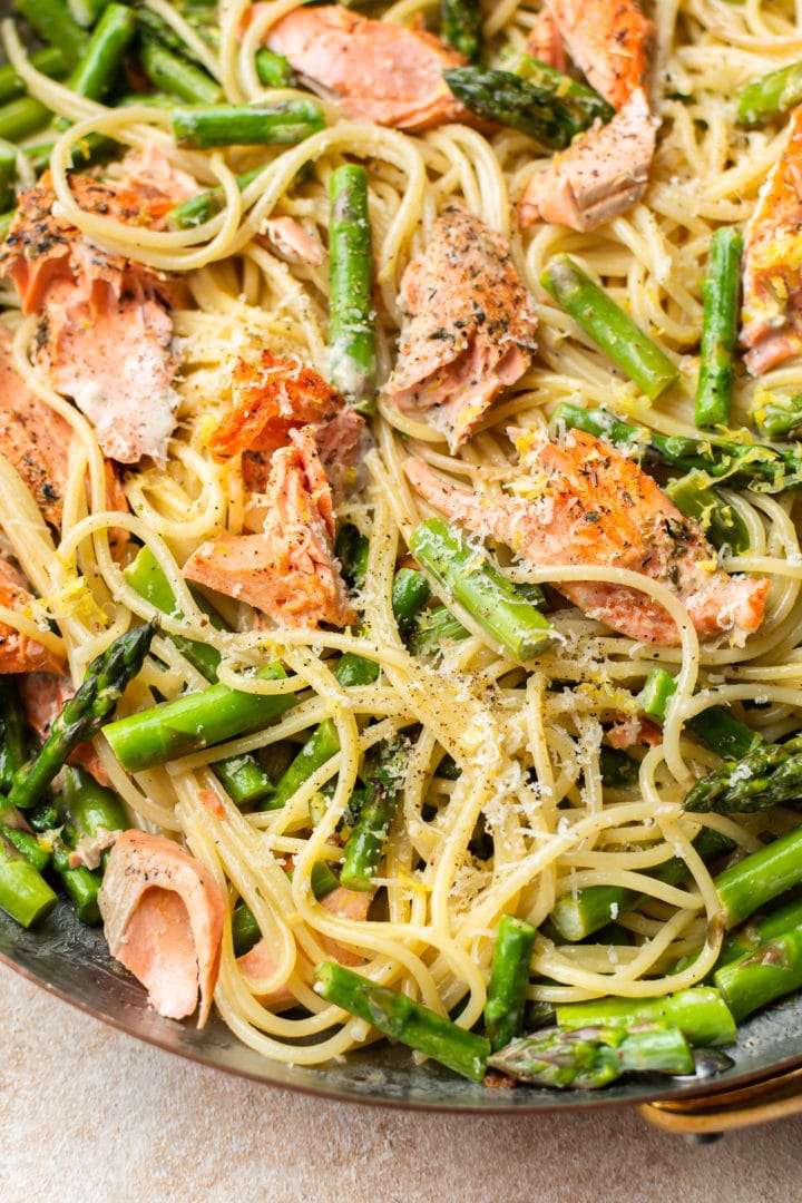 close-up in a copper skillet of creamy salmon and asparagus pasta