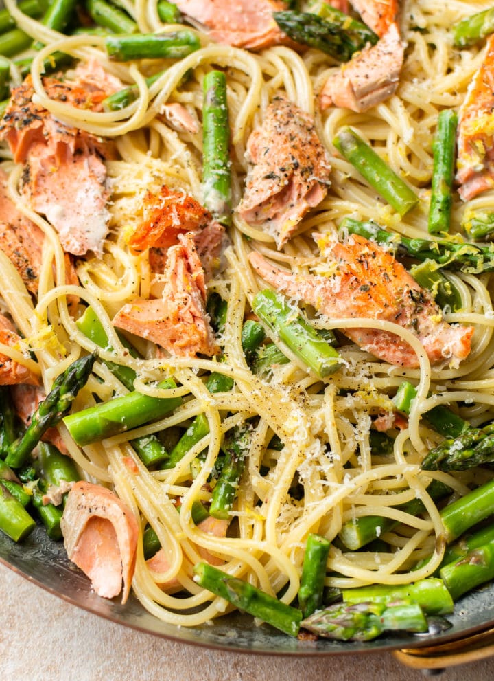 close-up in a copper skillet of creamy salmon and asparagus pasta
