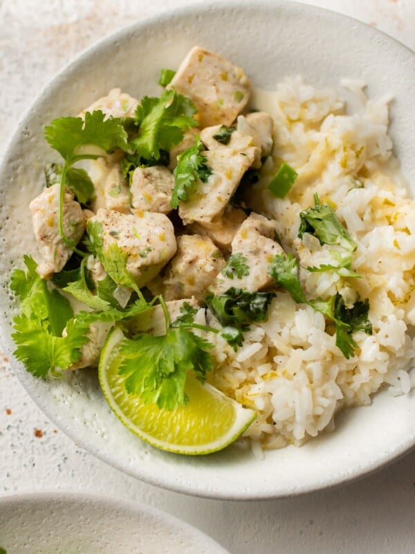 coconut lime chicken (2 bowls with chicken, sauce, cilantro, lime wedge, and rice)