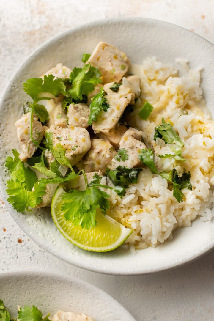 coconut lime chicken (2 bowls with chicken, sauce, cilantro, lime wedge, and rice)
