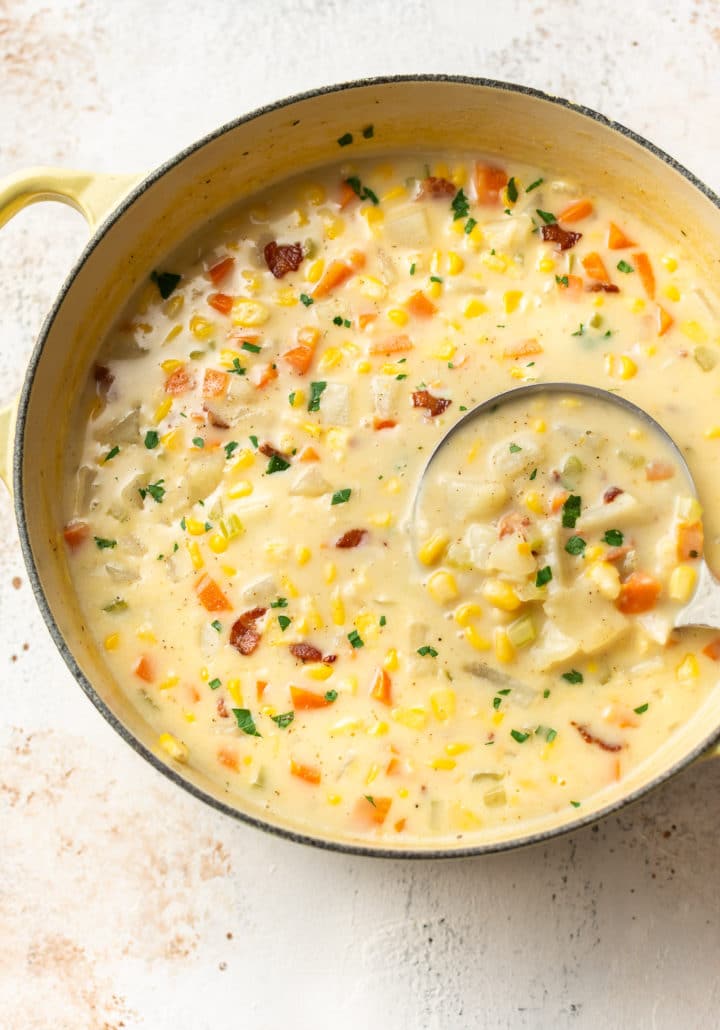 the best corn chowder in a yellow soup pot with a ladle