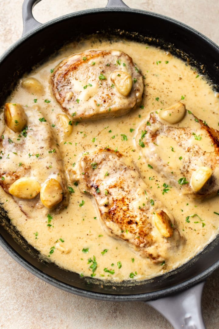 creamy garlic pork chops in a skillet