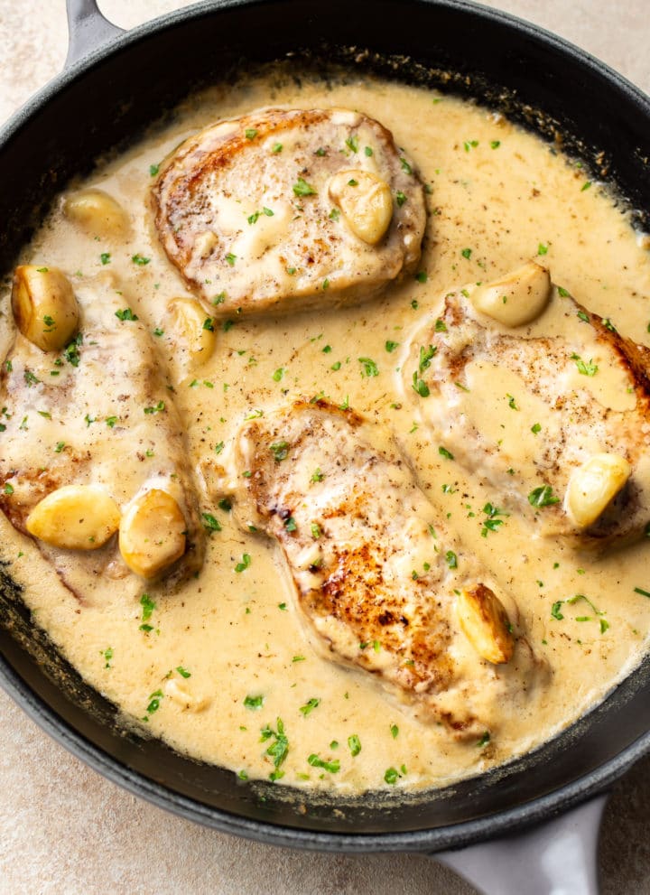 creamy garlic pork chops in a skillet