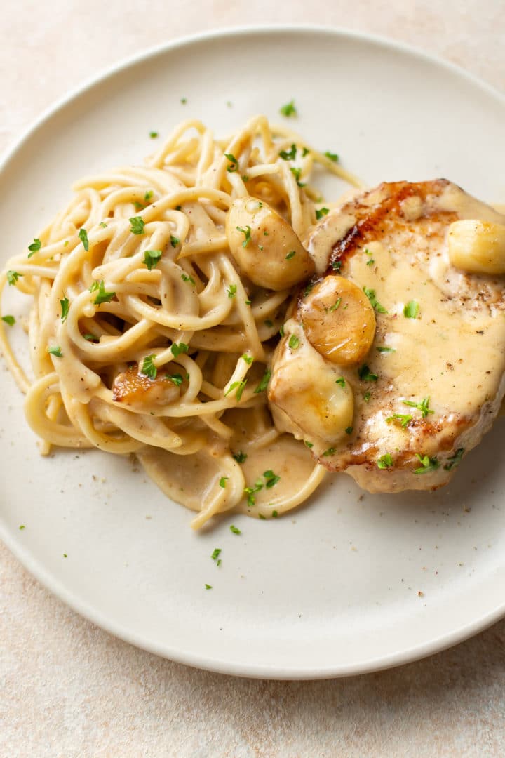 creamy garlic pork chops plated with spaghetti