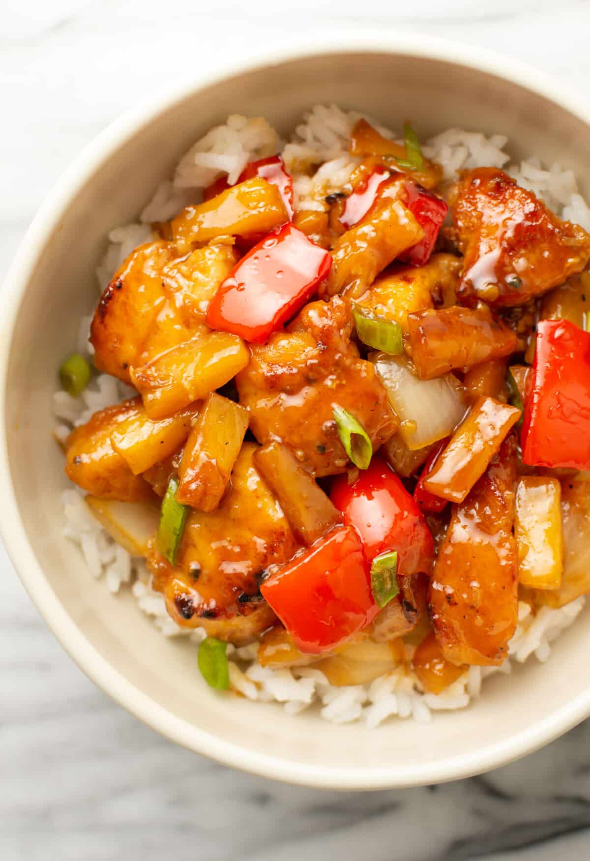 a bowl of pineapple chicken over rice