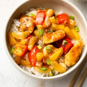 pineapple chicken on rice in a beige bowl