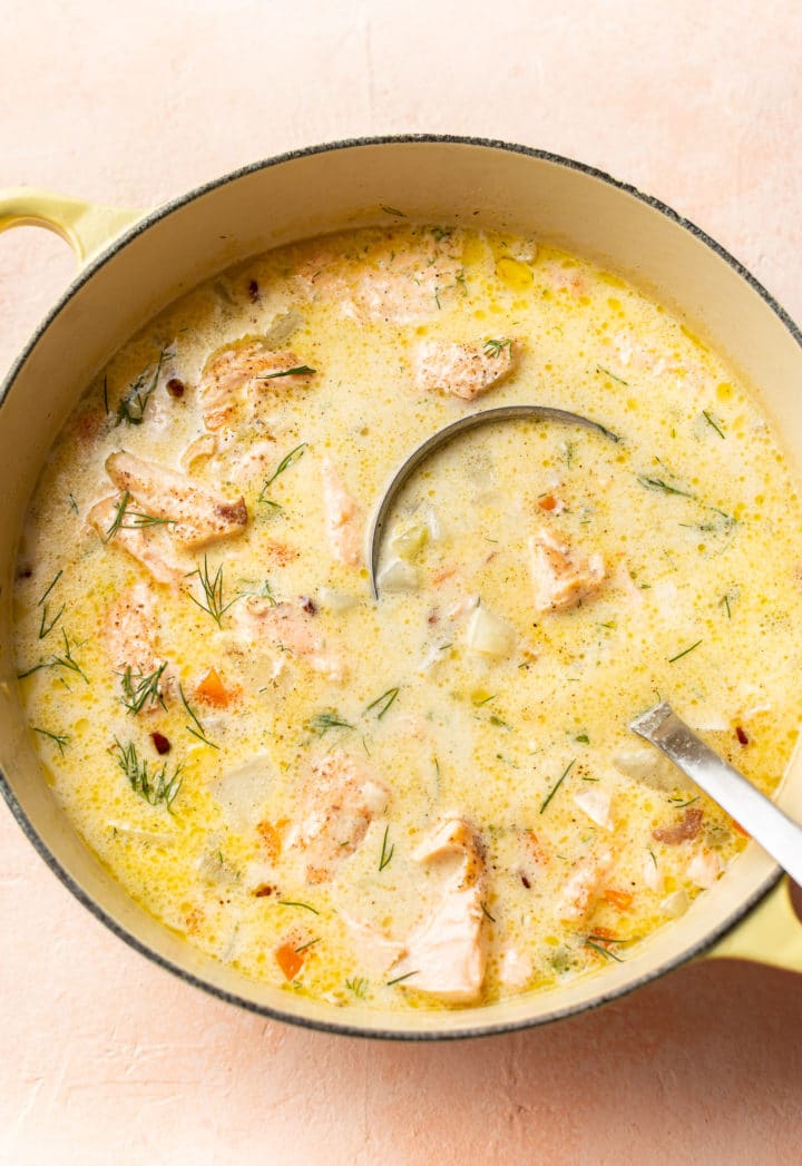 close-up of salmon chowder in a yellow soup pot (with ladle)