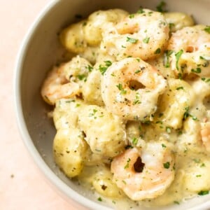 pesto shrimp gnocchi in a beige bowl