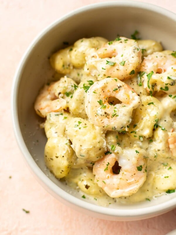 pesto shrimp gnocchi in a beige bowl