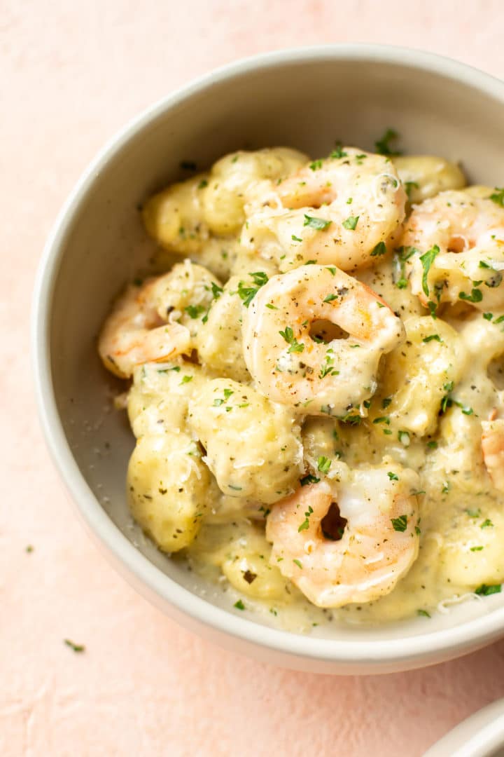 pesto shrimp gnocchi in a beige bowl