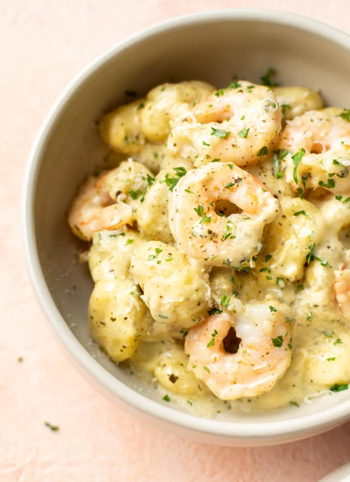 pesto shrimp gnocchi in a beige bowl